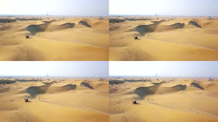 坐在沙漠中的人和骆驼