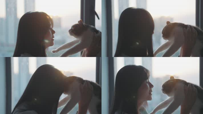 女孩在傍晚夕阳下的落地窗边抱着猫咪玩耍