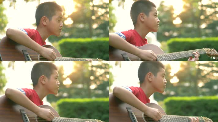 傍晚唯美夕阳下在小区草地上弹吉他的小男孩