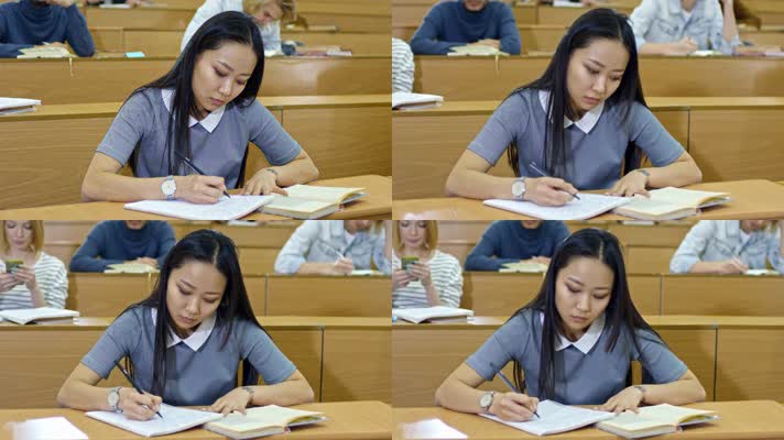 勤奋的亚洲女孩坐在讲堂的课桌前认真学习
